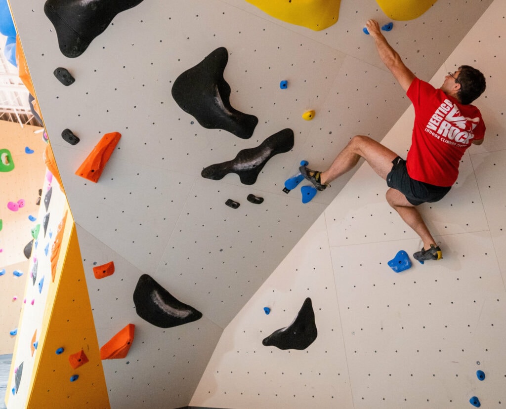 Indoor climber practicing quick movement and body control on a climbing wall